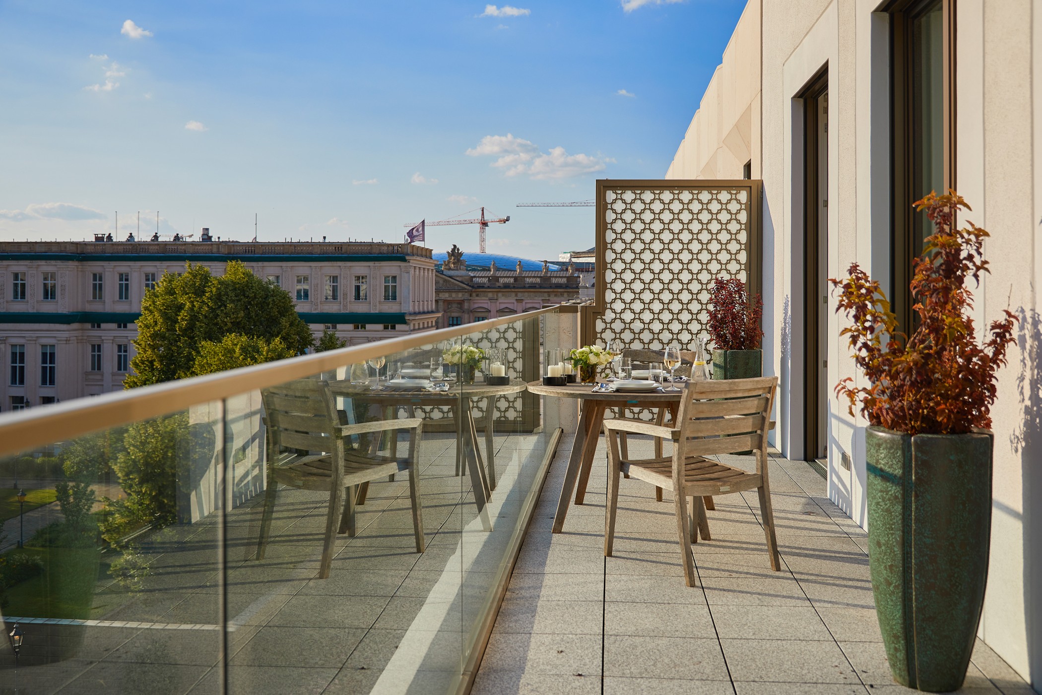 Großzügige Terrasse mit gedecktem Tisch und Blick auf die historischen Fassaden rund um den Schinkelplatz in Berlin-Mitte.