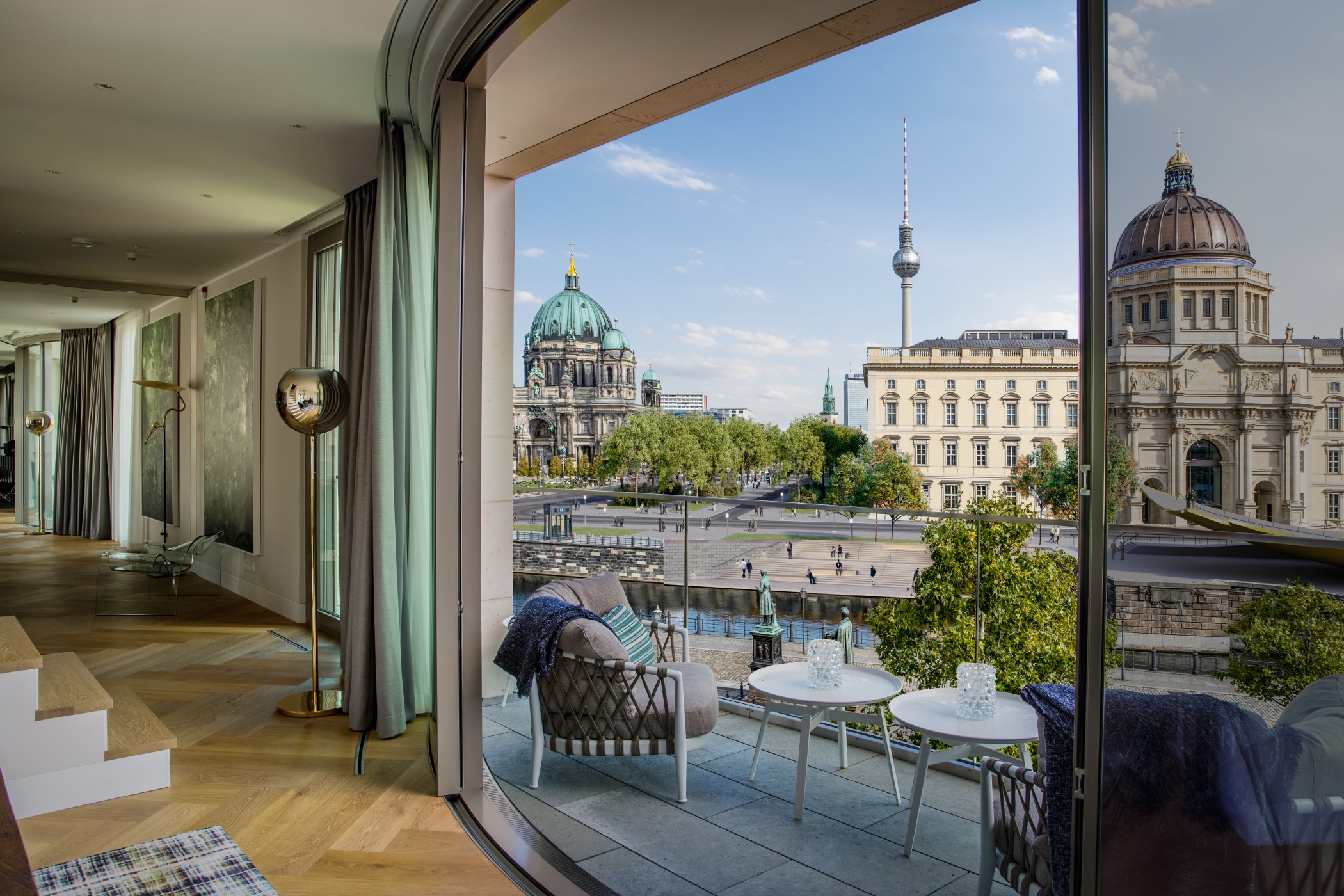 Großzügige Terrasse mit gedecktem Tisch und Blick auf die historischen Fassaden rund um den Schinkelplatz in Berlin-Mitte.