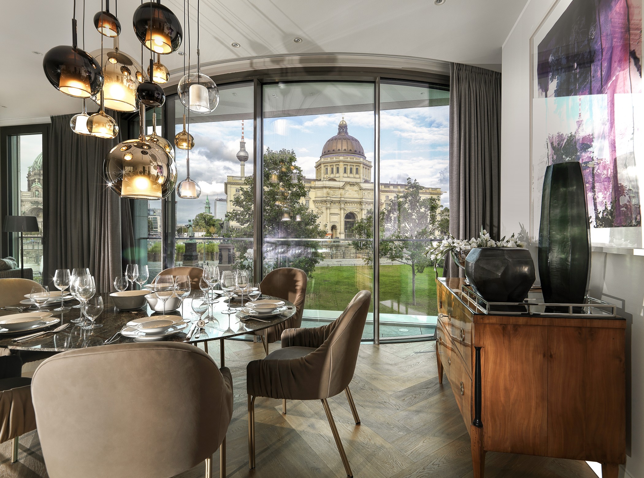 Elegantes Esszimmer einer Luxuswohnung am Schinkelplatz in Berlin-Mitte mit Blick auf das Humboldt Forum und den Fernsehturm.