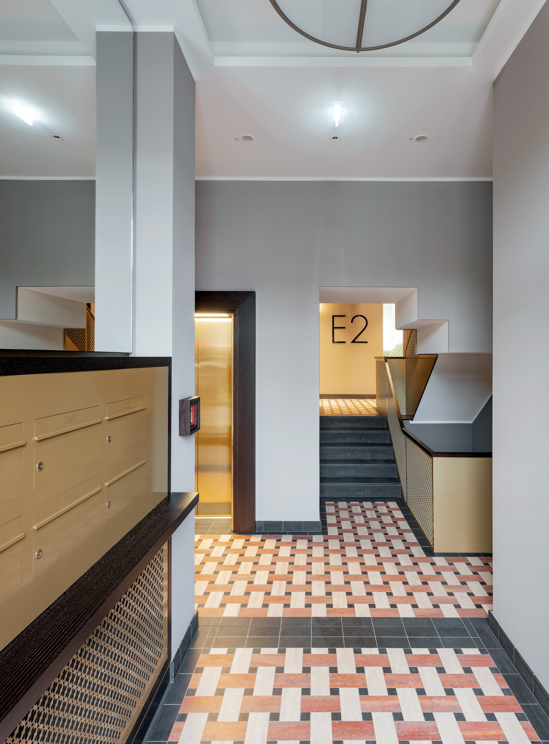 Hochwertig gestalteter Hauseingang am Schinkelplatz in Berlin-Mitte mit eleganten Fliesen, moderner Beschilderung und Aufzugsbereich.