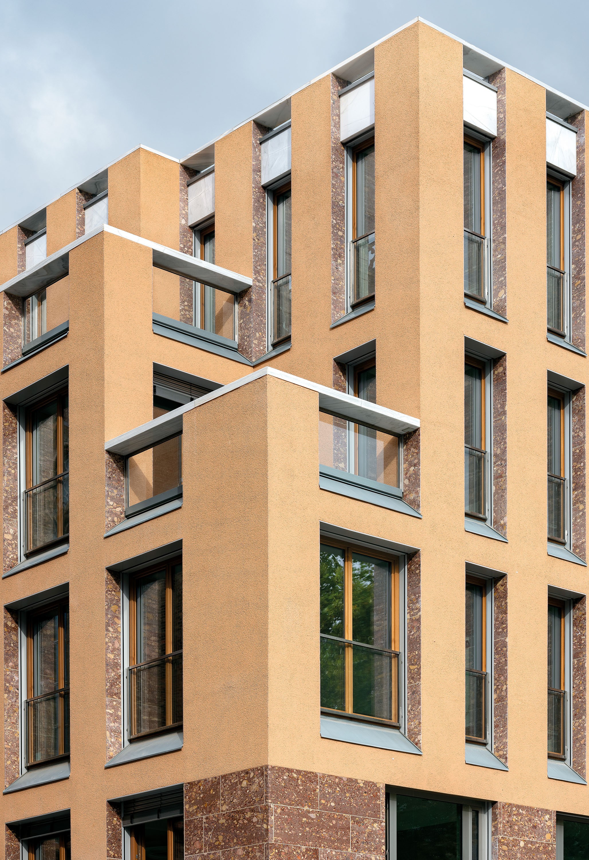 Detailansicht der modernen Fassadengestaltung mit versetzten Balkonen und großen Fenstern am Schinkelplatz in Berlin-Mitte.