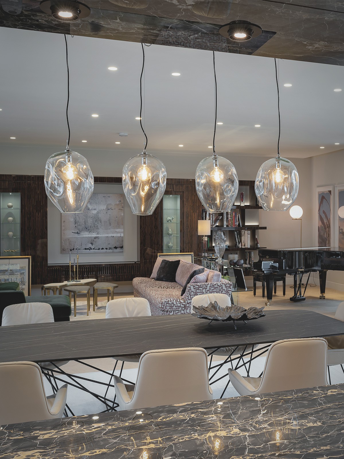 Elegantes Wohnzimmer mit großem Esstisch, Designbeleuchtung und Flügel in einer luxuriösen Wohnung am Schinkelplatz in Berlin.