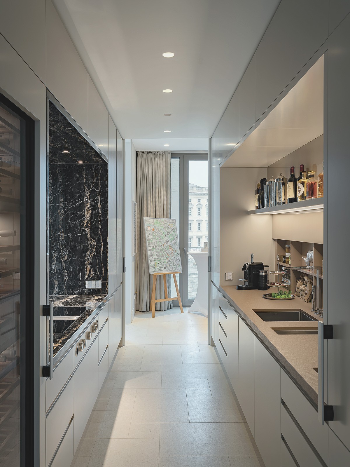 Luxuriöse Zweitküche mit Marmorwand, modernen Einbauten und Blick über den Schinkelplatz in Berlin