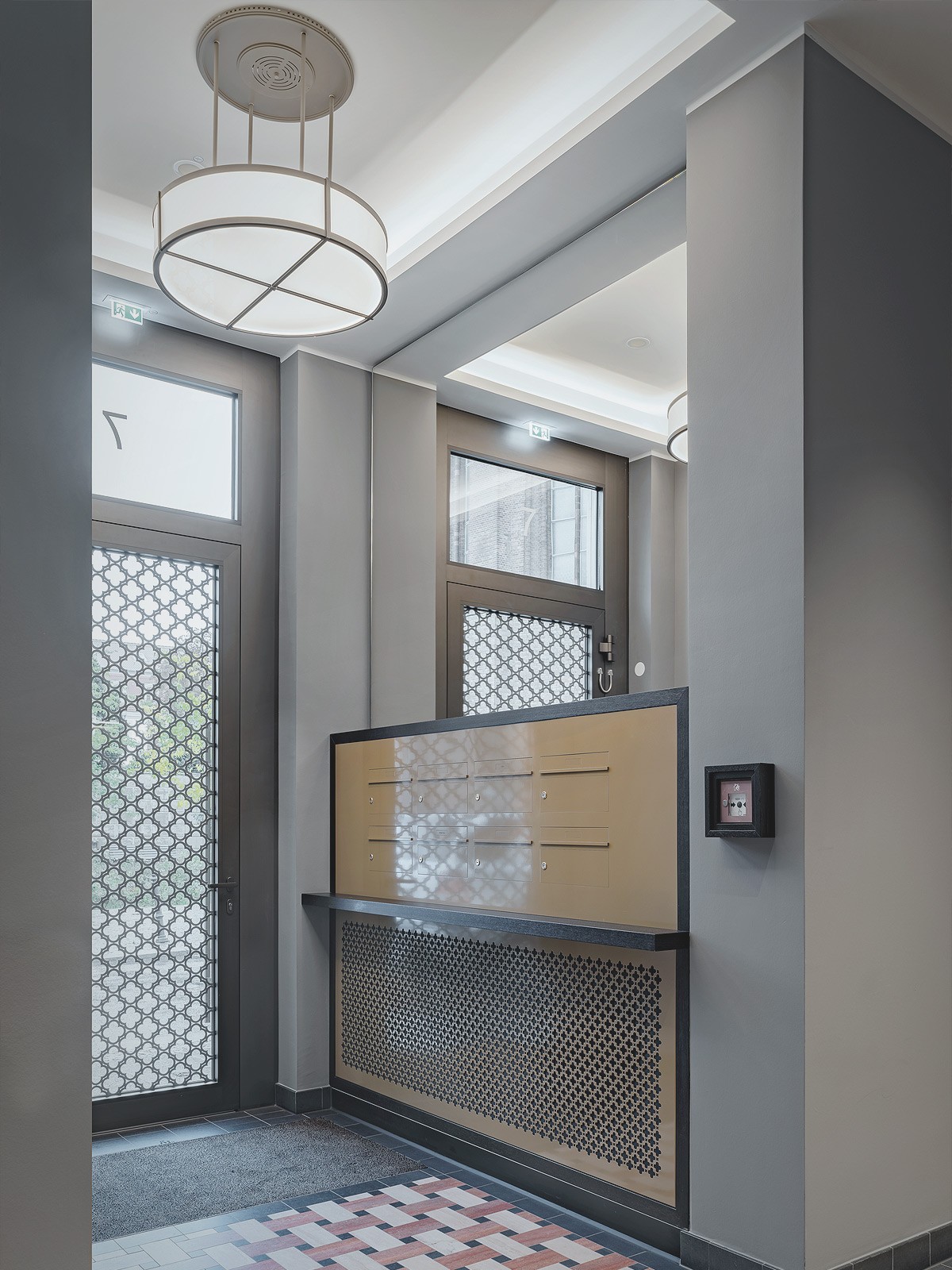 Hochwertig gestalteter Hauseingang am Schinkelplatz in Berlin-Mitte mit eleganten Fliesen, moderner Beschilderung und Aufzugsbereich.