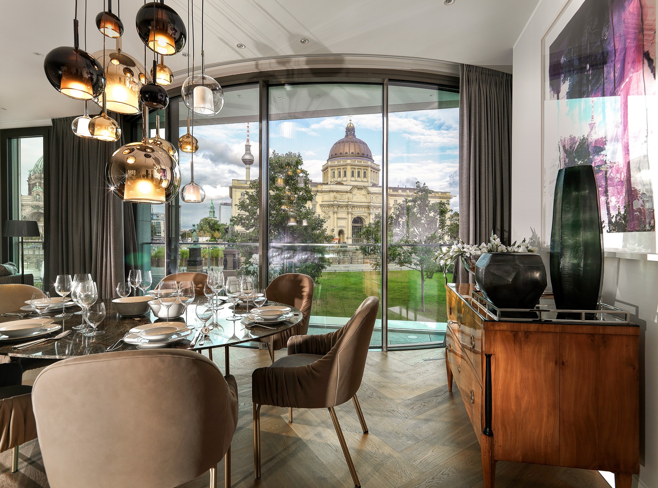 Elegantes Esszimmer einer Luxuswohnung am Schinkelplatz in Berlin-Mitte mit Blick auf das Humboldt Forum und den Fernsehturm.
