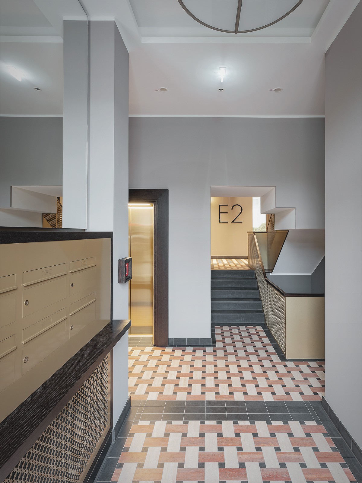 Hochwertig gestalteter Hauseingang am Schinkelplatz in Berlin-Mitte mit eleganten Fliesen, moderner Beschilderung und Aufzugsbereich.