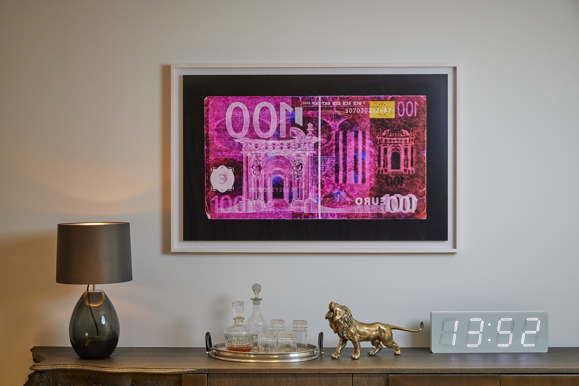 Innenansicht einer modernen Wohnung am Schinkelplatz in Berlin-Mitte mit Kunstwerk einer stilisierten 100-Euro-Banknote, Designobjekten und dekorativer Beleuchtung.