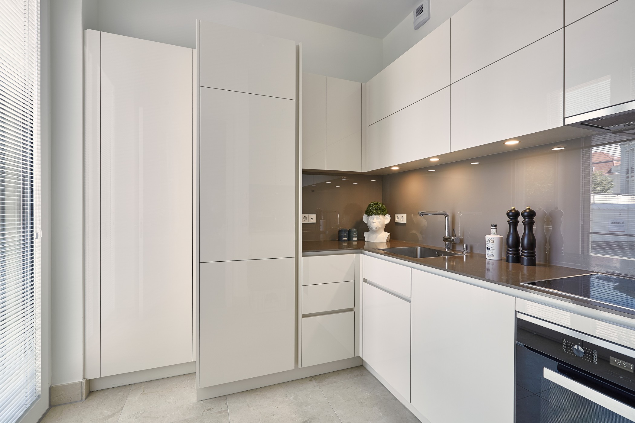 Moderne Einbauküche einer Luxuswohnung am Schinkelplatz in Berlin-Mitte mit hochglänzenden Fronten, klaren Linien und eleganter Arbeitsfläche.