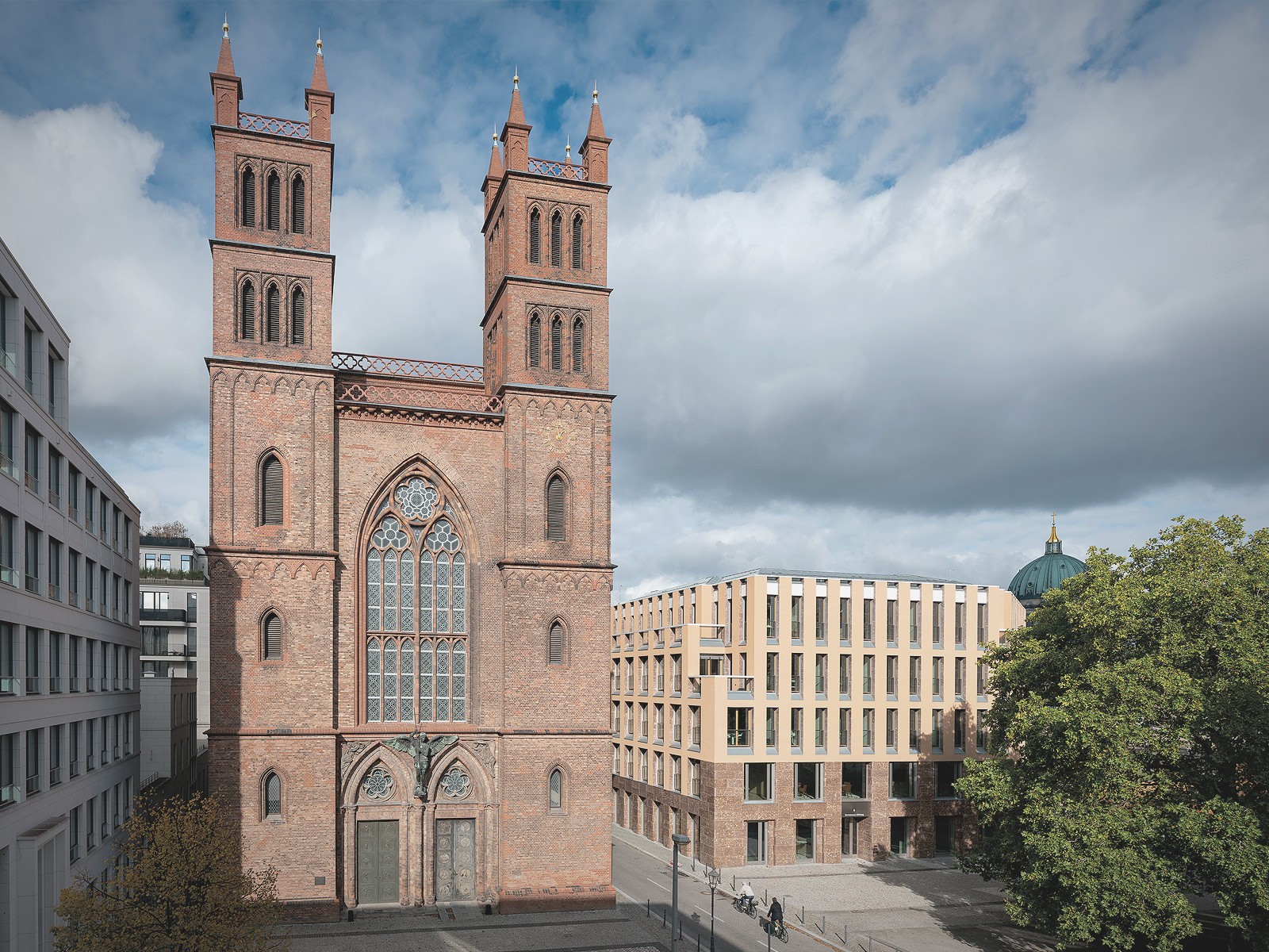 Ansicht der Friedrichswerderschen Kirche in Berlin-Mitte mit angrenzender moderner Wohnarchitektur am Schinkelplatz.