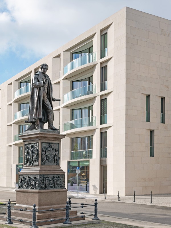 Statue von Karl Friedrich Schinkel vor einer modernen Wohnresidenz am Schinkelplatz in Berlin-Mitte.