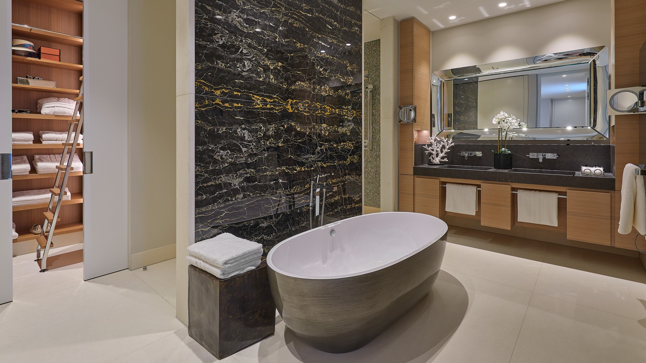 Luxuriöses Designer-Badezimmer mit freistehender Badewanne, dunkler Marmorwand, hochwertigem Doppelwaschtisch und offenem Handtuch-Schrank im exklusiven Wohnquartier am Schinkelplatz in Berlin.